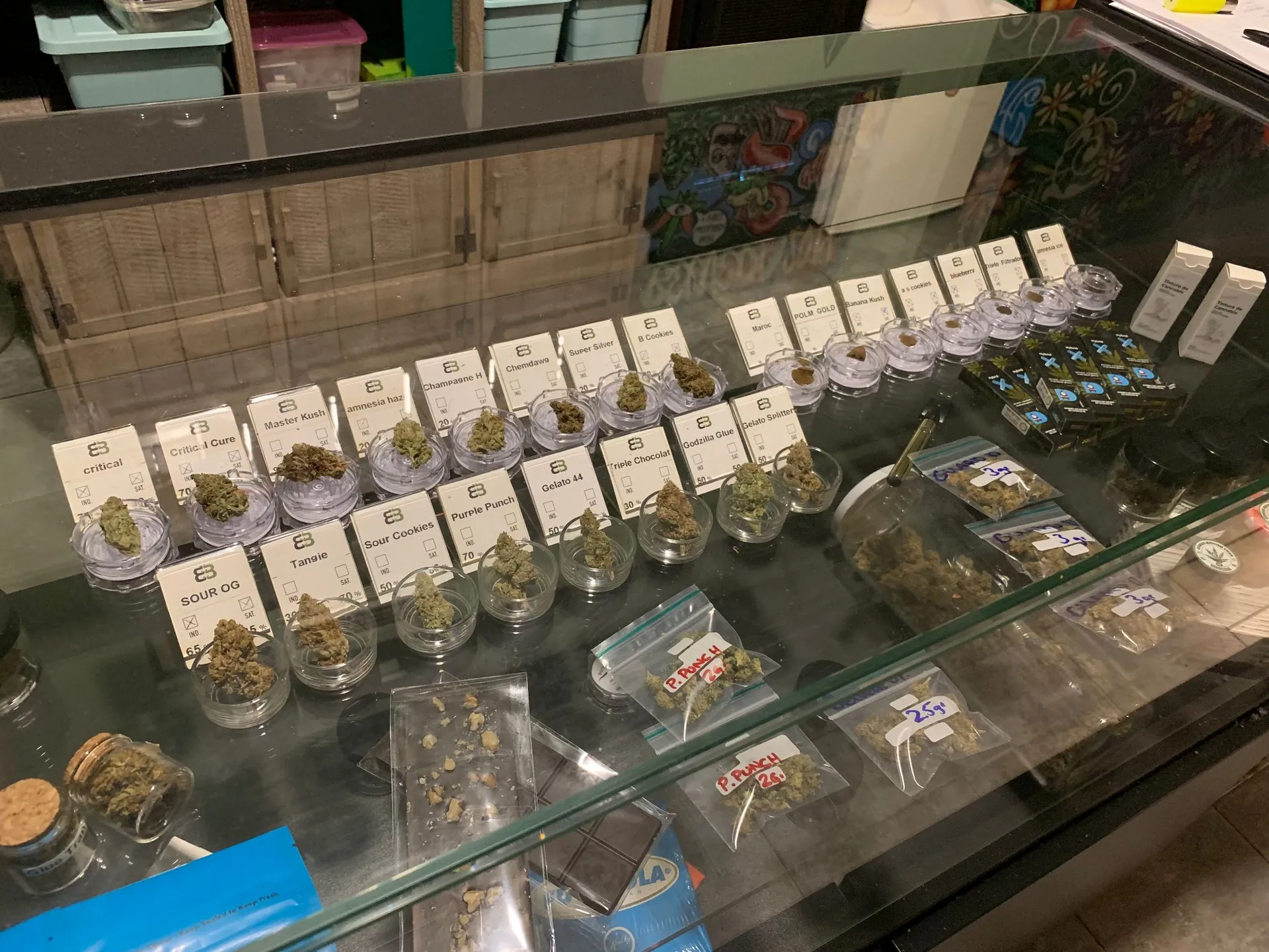 bocaux contenant différentes variétés de cannabis dans un dispensaire de type coffee shop